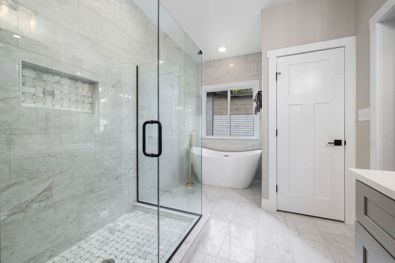 A frameless glass shower and a freestanding tub in a remodeled bathroom